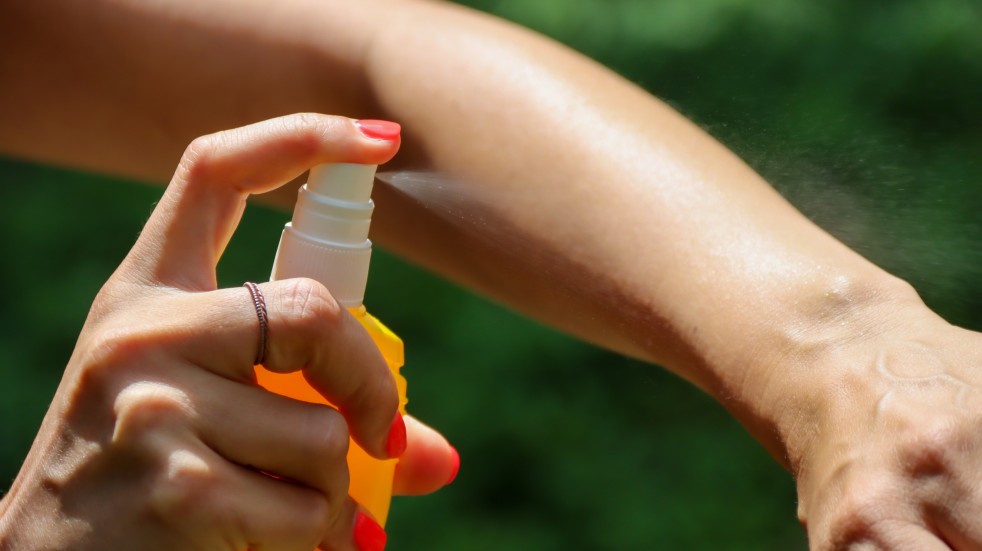 woman applying insect repellant